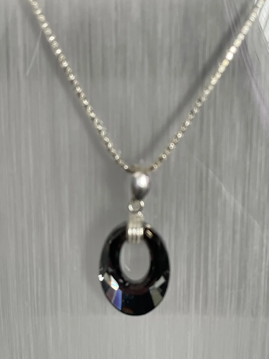 Dark faceted pendant on a delicate chain.