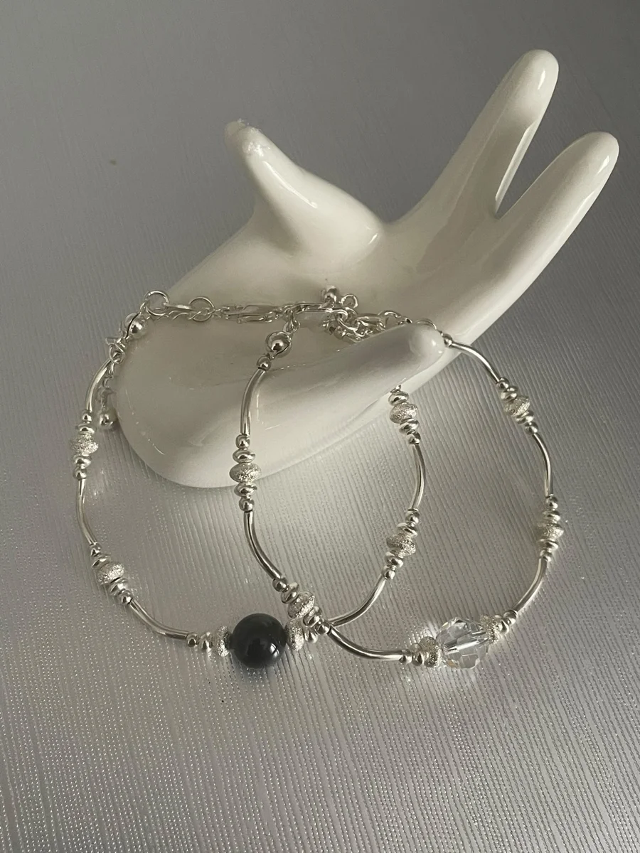 Delicate hoop earrings with a dark bead accent.