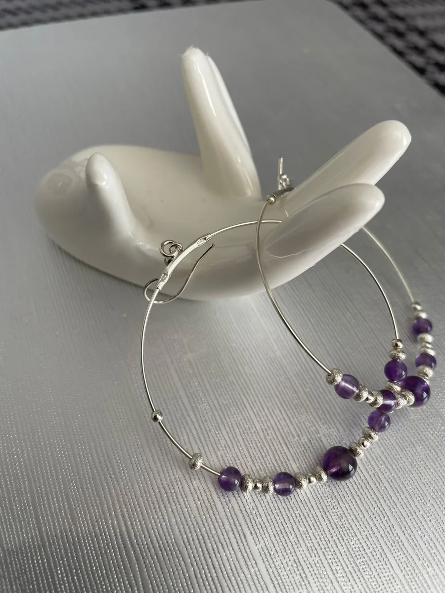 Hoop earrings with purple bead details.
